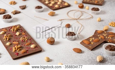 Handmade Milk Chocolate Bars With Nuts And Dried Fruits On White Background. Side View