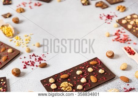 Raw Vegan Handmade Chocolate With Nuts And Dried Fruits. Chocolate Bars On White Concrete Background