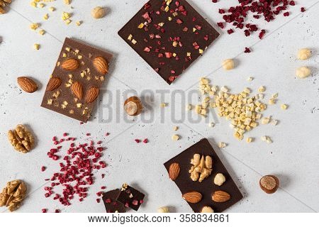 Dark And Milk Chocolate Bars With Nuts And Dried Fruits On Light Background. Homemade Organic Chocol
