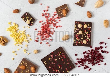 Raw Vegan Handmade Chocolate With Nuts And Dried Fruits. Milk And Dark Chocolate Bars On White Concr