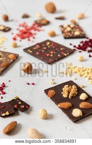 Homemade Milk And Dark Chocolate Bars With Dried Berries And Nuts On Light Background. Side View. Ch