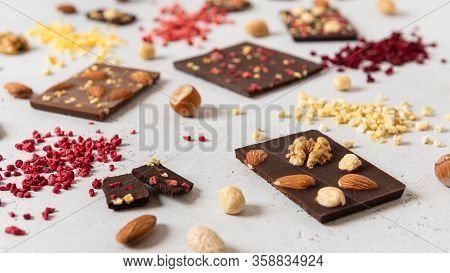 Raw Vegan Handmade Chocolate With Nuts And Dried Fruits. Milk And Dark Chocolate Bars On White Concr