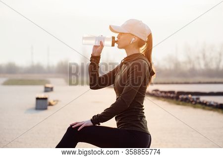 Beautiful Girl At Morning Workout Drinks Water From A Bottle