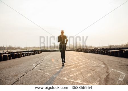 Morning Run Of A Young Girl On The Street In Black Leggings And Sneakers