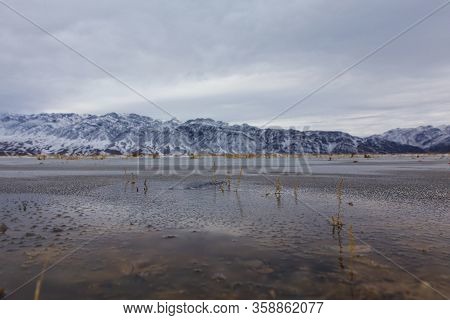 Bartogai Lake With Transparent Water With Mountains In Background In Winter Time Near Almaty, Kazakh