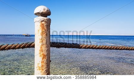 Long Pontoon On The Red Sea In Egypt. Pontoon For Descent Into The Water. Wooden Bridge On The Terri