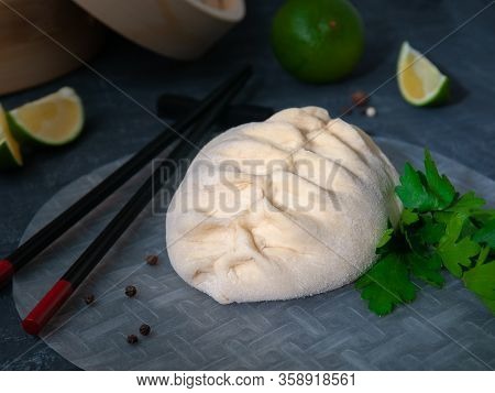 Pyans Bun Steamed. Filled With Chicken, Carrots And Cabbage. In The Background Are A Bamboo Double B