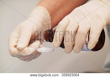 Doctor Gives An Antibiotic On A Plastic Spoon