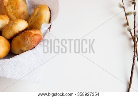 Patties In A Basket On A White Napkin And Willow Branches On White Background. Bakery Background. Ho