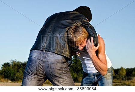Dois homens lutam ao ar livre. Conceito de roubo