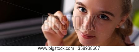 Girl In Office Sits In Front Laptop And Holds Pen. Inexperience, Excitement And Insecurity In Workpl