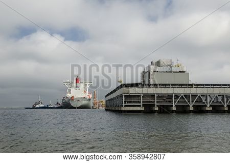 Lng Terminal And Gas Tanker - A Large Ship Maneuvers Into The Unloading Quay