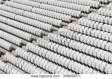 Rows Of White Empty Plastic Seats In A Stadium.