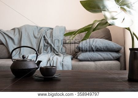 Cozy Living Room With Sofa. Cup And Kettle On Table Decorated Mostera. Scandinavian Interior. Stay A