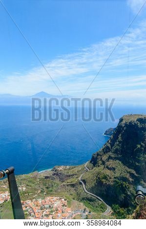 Views Of Mount Teide, A Village And A Cliff From The Glass Interior Of The Mirador De Abrante On The