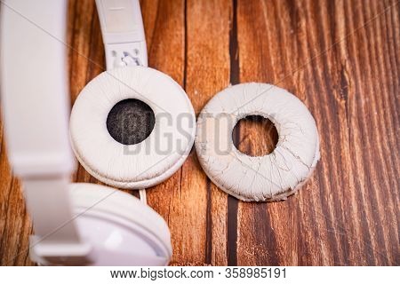 Need A Replacement Embouchures On Old White Earbud. Repair Accessories.wooden Background