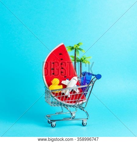 Tropical Beach Concept Made With Summer Things In Shopping Troley On Blue Background. Creative Minim