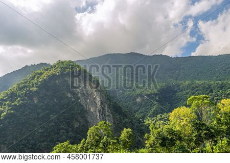 Beautiful Scenic Of A Forest Coverd All Over The Mountain With Th Cloudy Sky.