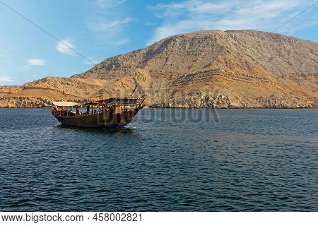 Khasab, Oman - July 2, 2022: Tourist Dhow Boat In Mountain Fjords.