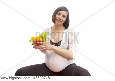 Pregnancy Concepts. Portrait Of Caucasian Brunette Woman In White Shirt Sitting On Big Fitball While