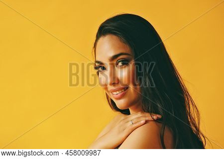 Headshot Beauty Shot Of Hispanic Latina Woman Smiling Young Adult With Hand On Shoulder On Black Lon