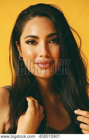 Headshot Beauty Shot Of Hispanic Latina Woman Smiling With Young Adult With Hands On Black Long Hair