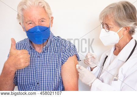 Doctor Giving Injection To Senior Caucasian Man, Old Retired Receiving Booster Of Covid 19 Vaccine, 