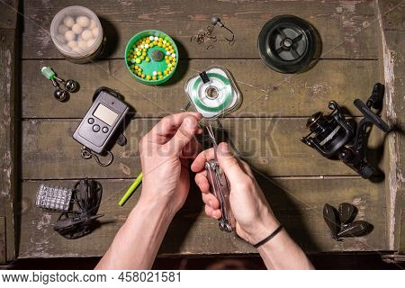 The Fisherman Ties The Line To The Hook. Fisherman's Hands And Tools For Fishing Montage. Cut The Li