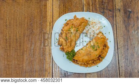 Enchilada With Salad Served In A Plate On A Wooden Table, View Of Two Enchiladas With Salad Served I
