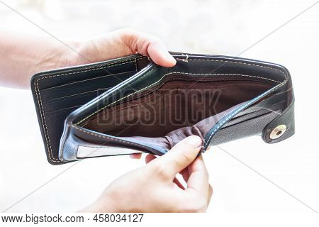 Man Holding An Empty Wallet Isolated On White Background.
