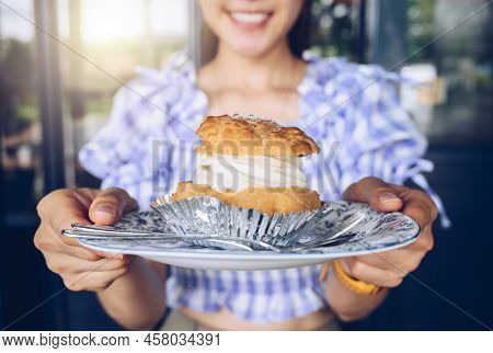 Close Up Of Woman Holding A Dish Of Choux Cream Before Eating. Choux Cream Or Choux Pastry Is A Ligh