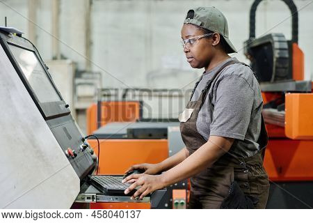 African Female Operator In Protective Glasses Looking At Process On Monitor While Controlling The Co
