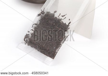 Tea Bag Of Dry Black Tea Leaves Made With Food Plastic Mesh Rectangular Shape Close-up On A White Ba