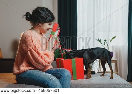 Happy Young Woman Giving Present For Her Dog From A Gift Box.