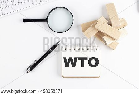 Wto - World Trade Organization Word Written On A Notebook With Block Magnifier And Pen , Business Co