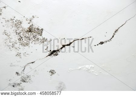 Infiltration Of Water, Mold And Cracks In The Wall And White Roof Of The House