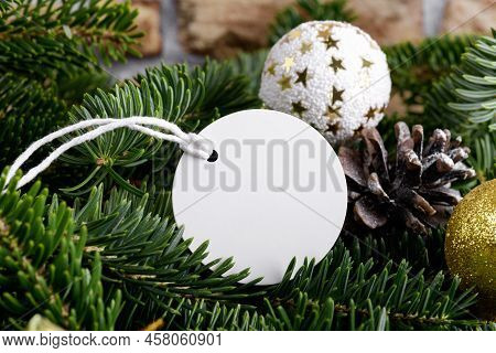 Christmas Round White Tag Mockup With White Cord, Close Up On Natural Fir Tree Branch, With Cones An