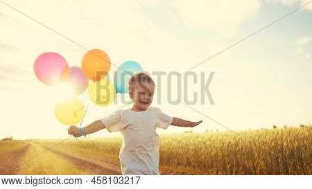 Little Baby Boy Run With Balloons In The Park In Nature. Happy Lifestyle Family Holiday Birthday Kid