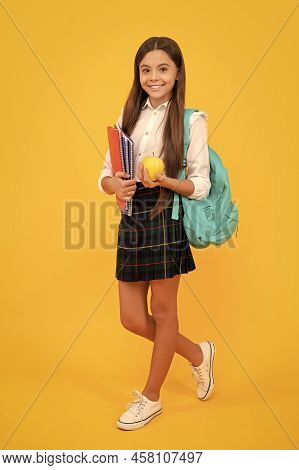 Smiling Teen Girl With Backpack And Workbooks Hold Apple Lunch In Uniform Full Length, School Lunch.