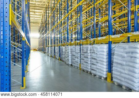 Interior Of A Modern Warehouse Storage Of Retail Shop With Pallet Truck Near Shelves. Rows Of Steel 