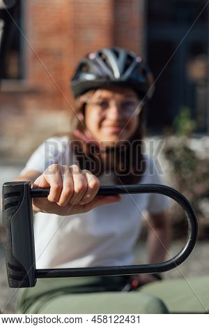 Young Female In Bicycle Helmet Hold Bicycle U Lock