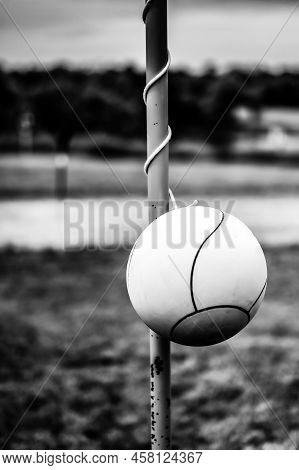 Tetherball Sitting Idle Next To The Pole In A Backyard.