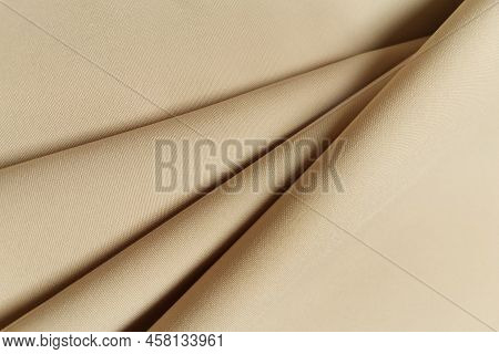 Beige Crumpled Or Wavy Fabric Texture Background. Abstract Linen Cloth Soft Waves. Gabardine Wool Fa