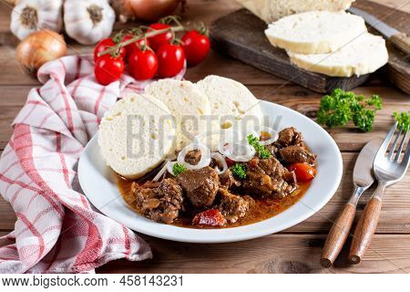 Traditional Czech Goulash With Dumplings On Wooden Table