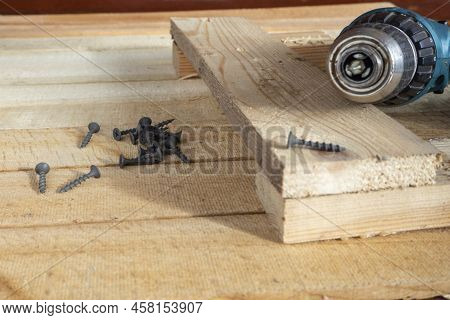 Self-tapping Screws And A Drill-screwdriver On Wooden Boards. Home Life, Diy