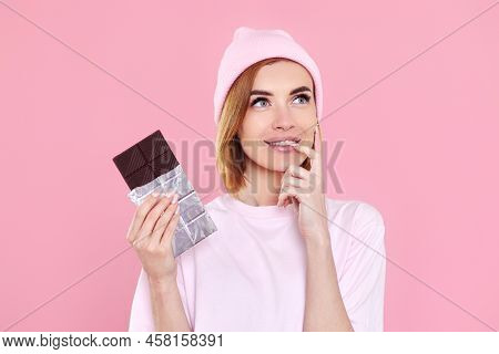 Blonde Woman In T-shirt And Hat Holding Chocolate Bar