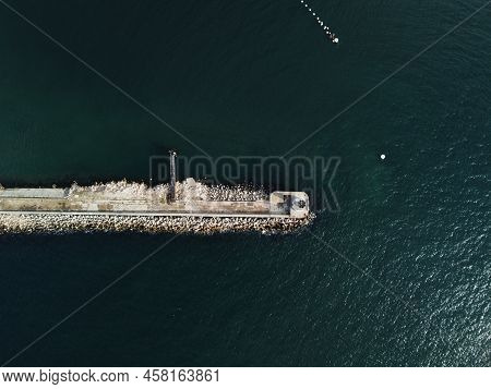 Aerial Drone View Of A Breakwater. Tetrapod Pier Along The Shore, Sea Waves Breaking On Tetrapod Pie