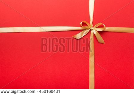 Top View Of Gold Ribbon Rolled And Yellowbow Isolated On Colored Background. Flat Lay With Copy Spac