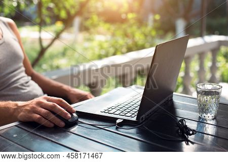 Working At A Laptop In The Outdoor Courtyard - Men\'s Hands Close-up. Home Office, Remote Work, Remo