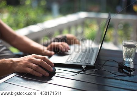 Working At A Laptop In The Outdoor Courtyard - Men\'s Hands Close-up. Home Office, Remote Work, Remo